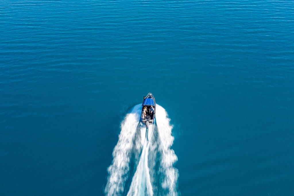 Top-down drone view of fishing boat surrounded by water on a New Zealand lake