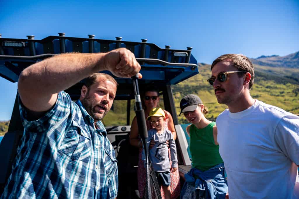 Fish being weighed on a fishing charter while two people check the scale together