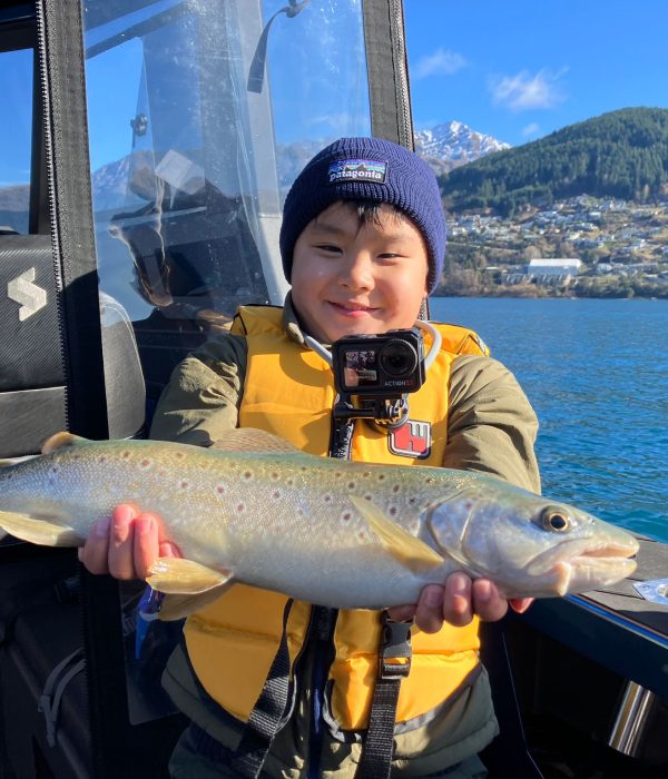 boy_caught_big_trout_fishing_charter_queenstown boy_caught_big_trout_fishing_charter_queenstown