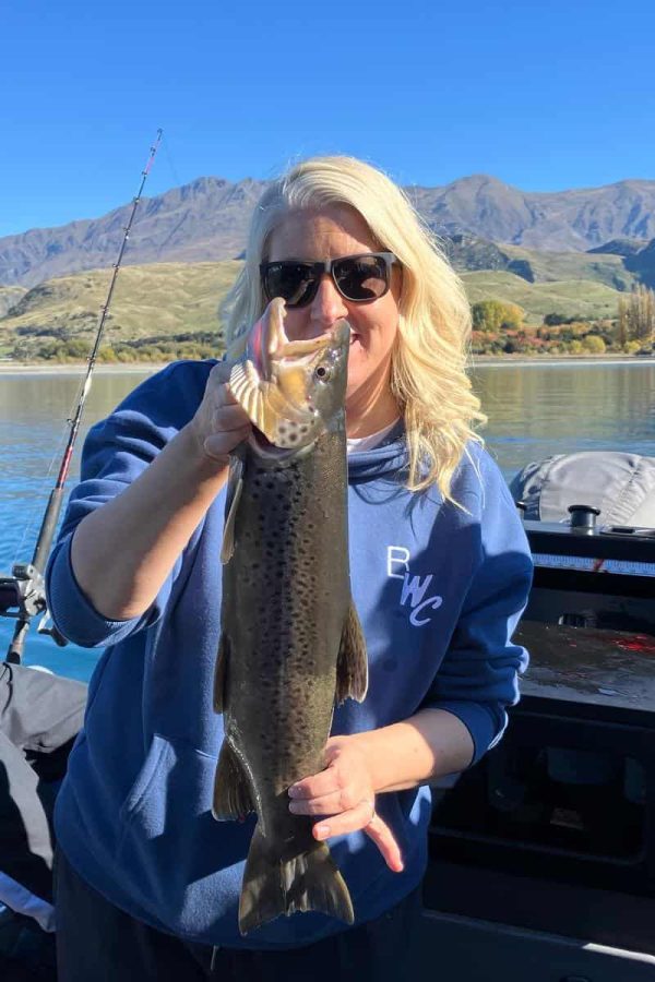 woman-holding-big-brown-trout-lake-wanaka Woman proudly holding a large brown trout on a fishing charter at Lake Wānaka